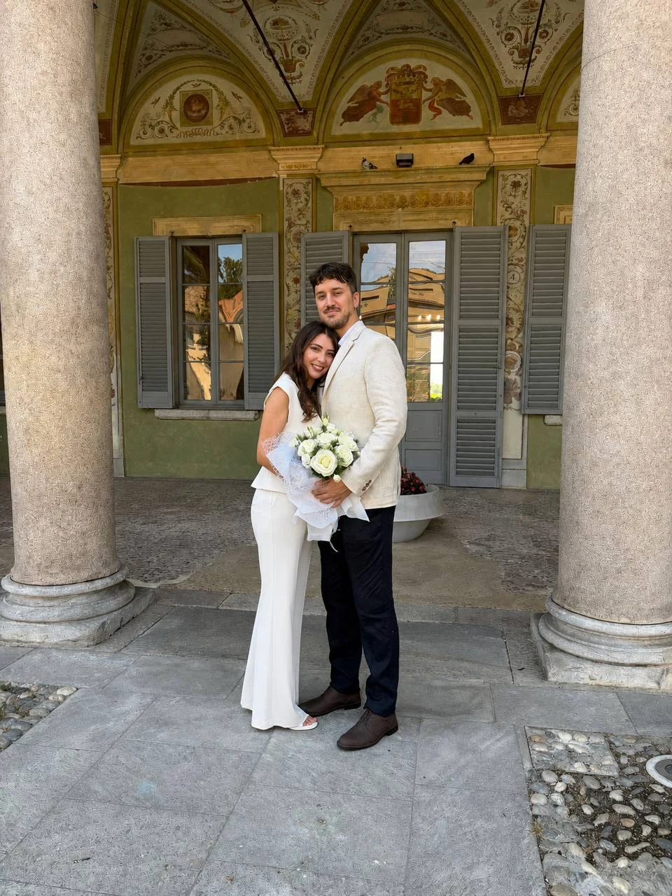 Gli sposi abbracciati davanti a un palazzo storico